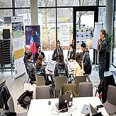 Mehrere Personen arbeiten an Laptops, während sie an einem Tisch zusammensitzen und Ideen austauschen.