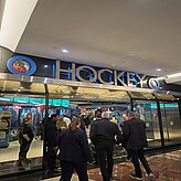 Teilnehmende stehen vor einem Eishockey-Stadioneingang mit dem Schriftzug „Hockey“. Entstanden bei einem Programmpunkt der Delegationsreise in Kanada.