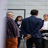 Menschen stehen zusammen und führen ein Gespräch miteinander.