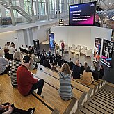 Die unerwarteten Aha-Momente: Was passiert, wenn Kreative ins Spiel kommen: TJ Graebe, Problemlöser, isento GmbH und Dr. Jürgen Baier, Geschäftsführer, isento GmbH, sprechen vorne auf der Bühne zum Publikum.