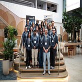 Eine Gruppe von Menschen steht auf einer Treppe in einer Lobby.