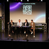 Das Bild zeigt vier Personen die auf einer Bühne zusammensitzen