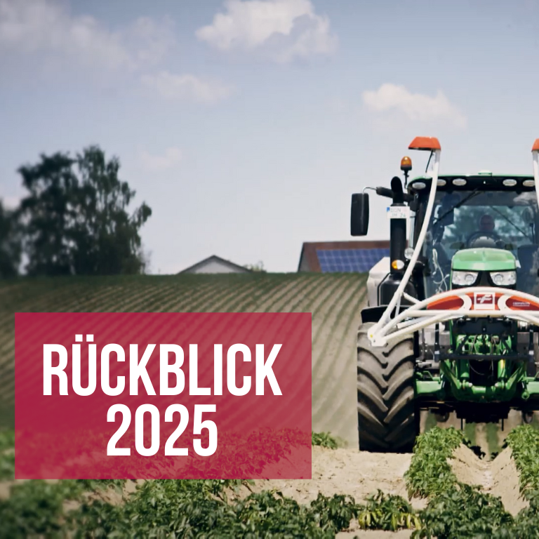 Traktor fährt auf einem Feld auf die Kamera zu