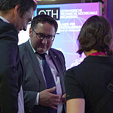 Das Bild zeigt zwei Männer und eine Frau die sich unterhalten