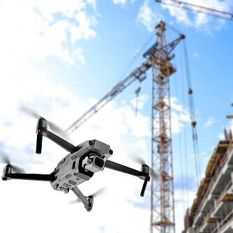 Im Vordergrund Drohne am Himmel im Hintergrund eine Baustelle