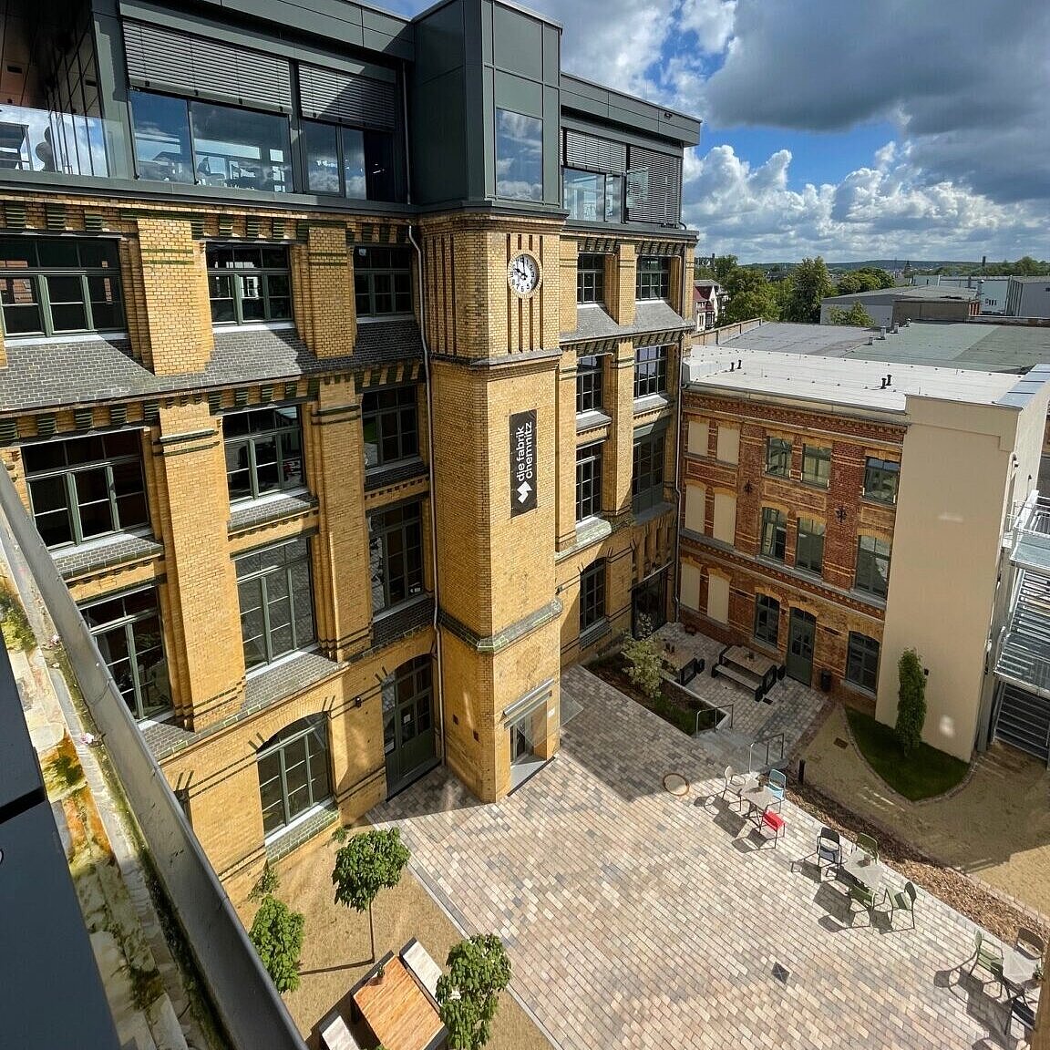 Ein Panorama eines mehrstöckigen gelben Hauses aus der Vogelperspektive. 