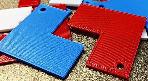 Das Bild zeigt ein optimiertes Bauteil in Blau und ein nicht optimiertes Bauteil in Rot