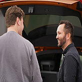 zwei Teilnehmende am Auto