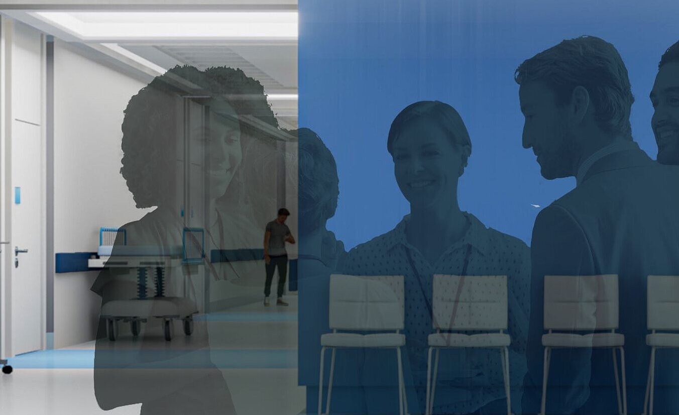 Das Bild zeigt einen Krankenhausflur mit einer Gruppe von Menschen hinter einer tealfarbenen, durchscheinenden Wand, die sich unterhalten. Im Hintergrund warten oder bewegen sich weitere Personen.