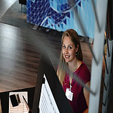 Claudia Keller smiling into the camera sitting behind the scenes