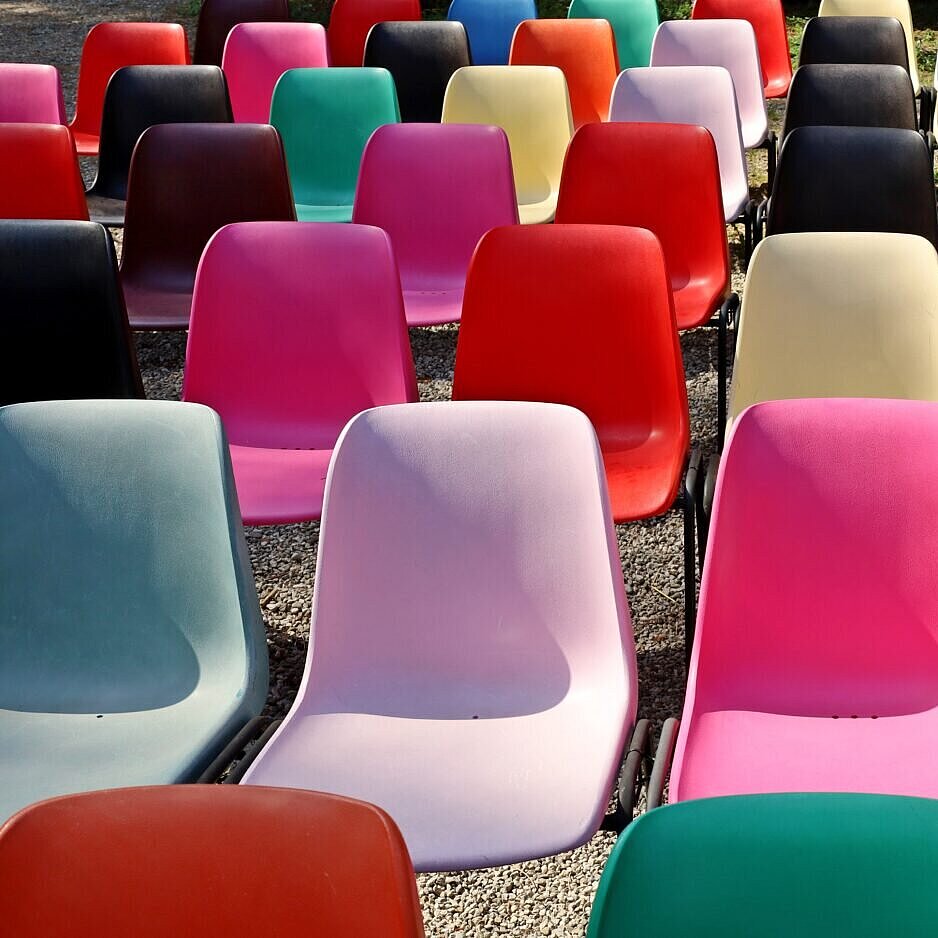Viele bunte Stühle stehen zusammen