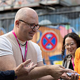 Das Bild zeigt einen Mann der einen Kartentrick vorführt