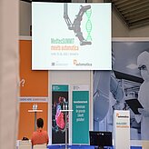 Mehrere Roll-up-Banner stehen nebeneinander in einer Reihe. Die Banner sind farblich unterschiedlich gestaltet – unter anderem in Orange, Blau, Grün und Weiß – und zeigen verschiedene Grafiken und Texte