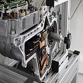 Exponat im Rahmen der Ausstellung zeigt den Motor eines Autos, mit Fokus auf seine technischen Details.