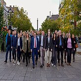Teilnehmende stehen in einer Straße mit herbstlicher Umgebung, im Hintergrund Gebäude und Bäume. Das Foto wurde während der Delegationsreise in Kanada gemacht.