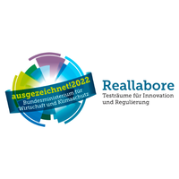 Farbiges Logo mit stilisiertem Globus und dem Schriftzug 'Reallabore Testräume für Innovation und Regulierung' sowie einem Banner mit dem Text 'ausgezeichnet! 2022 Bundesministerium für Wirtschaft und Klimaschutz