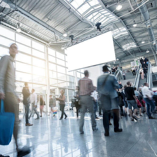 Eingangsbereich einer Messehalle mit vielen Messebesuchern