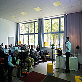 Gesamtüberblick über den Raum mit den Teilnehmenden und einem Referierenden