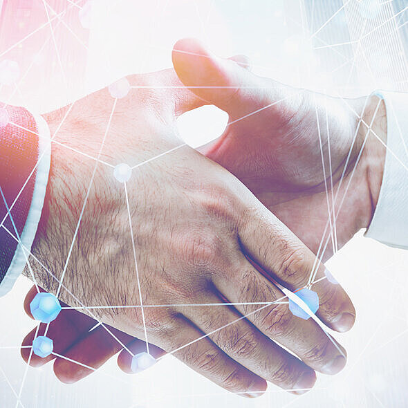 Zwei Hände reichen sich vor einer virtuellen Struktur