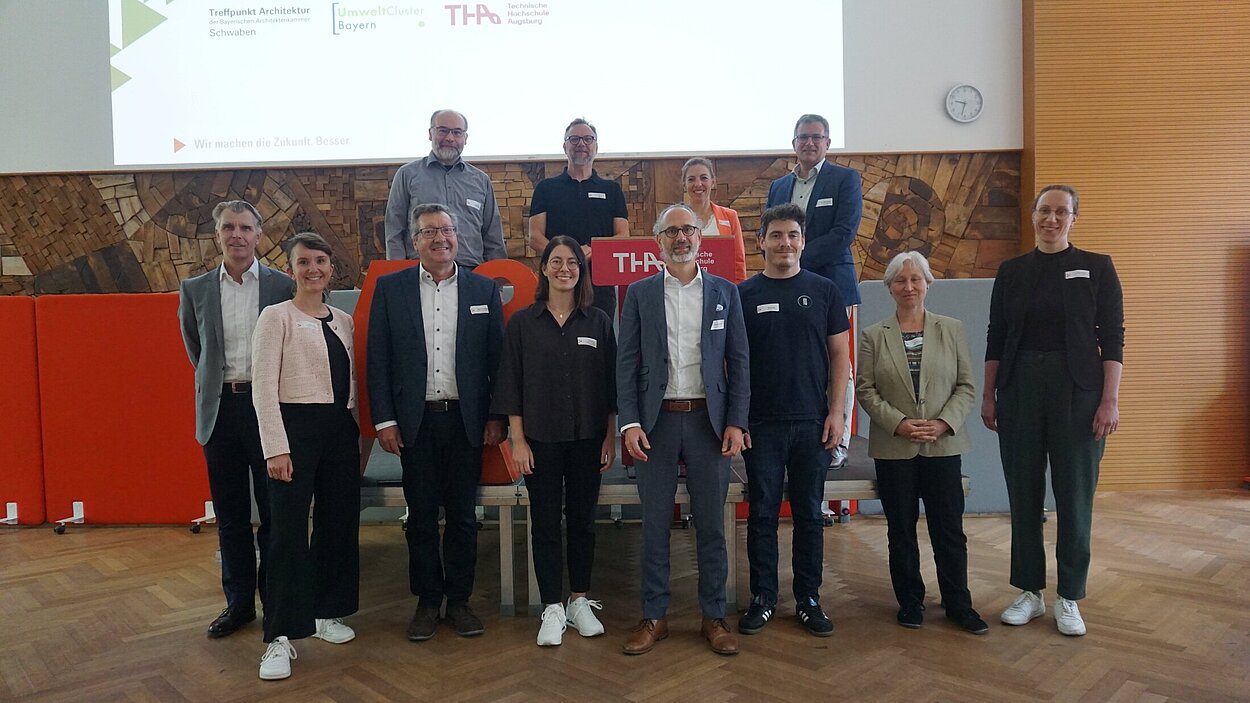 Team steht zusammen vor Leinwand