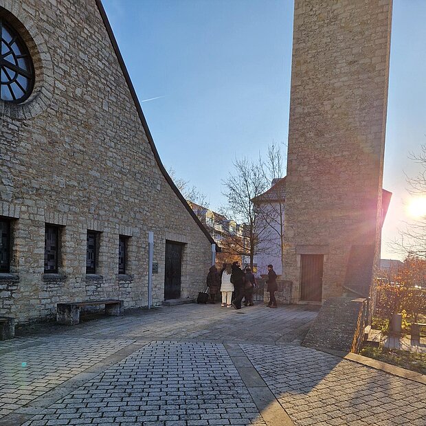 Blick in einen Kirchenhof. Der Kirchenhof steht separat rechts im Bild. 