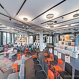 Heller, modern eingerichteter Konferenzraum bei Design Offices München Bogenhausen mit bodentiefen Fenstern, stilvollen Deckenleuchten und farbenfrohen Sitzgelegenheiten für Workshops und Events.