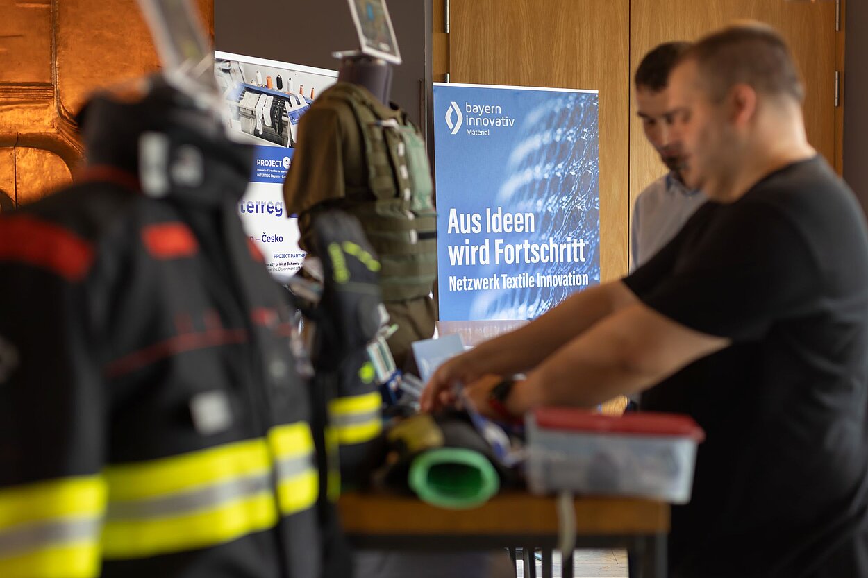 Zwei Personen sehen sich Schutzkleidung an
