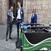 Ein Mann und eine Frau stehen neben einer grünen und schwarzen Maschine.