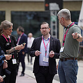 Das Bild zeigt zwei Männer und eine Frau die sich unterhalten