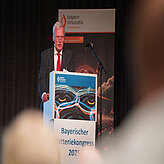 Das Bild zeigt einen Redner am Pult beim Bayerischen Batteriekongress 2025.