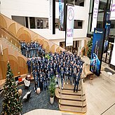 Menschenansammlung auf einer Treppe in einem Lobbybereich.