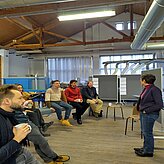 Referentin refreriert vor einer Gruppe in einem Labor-Sägewerk. 