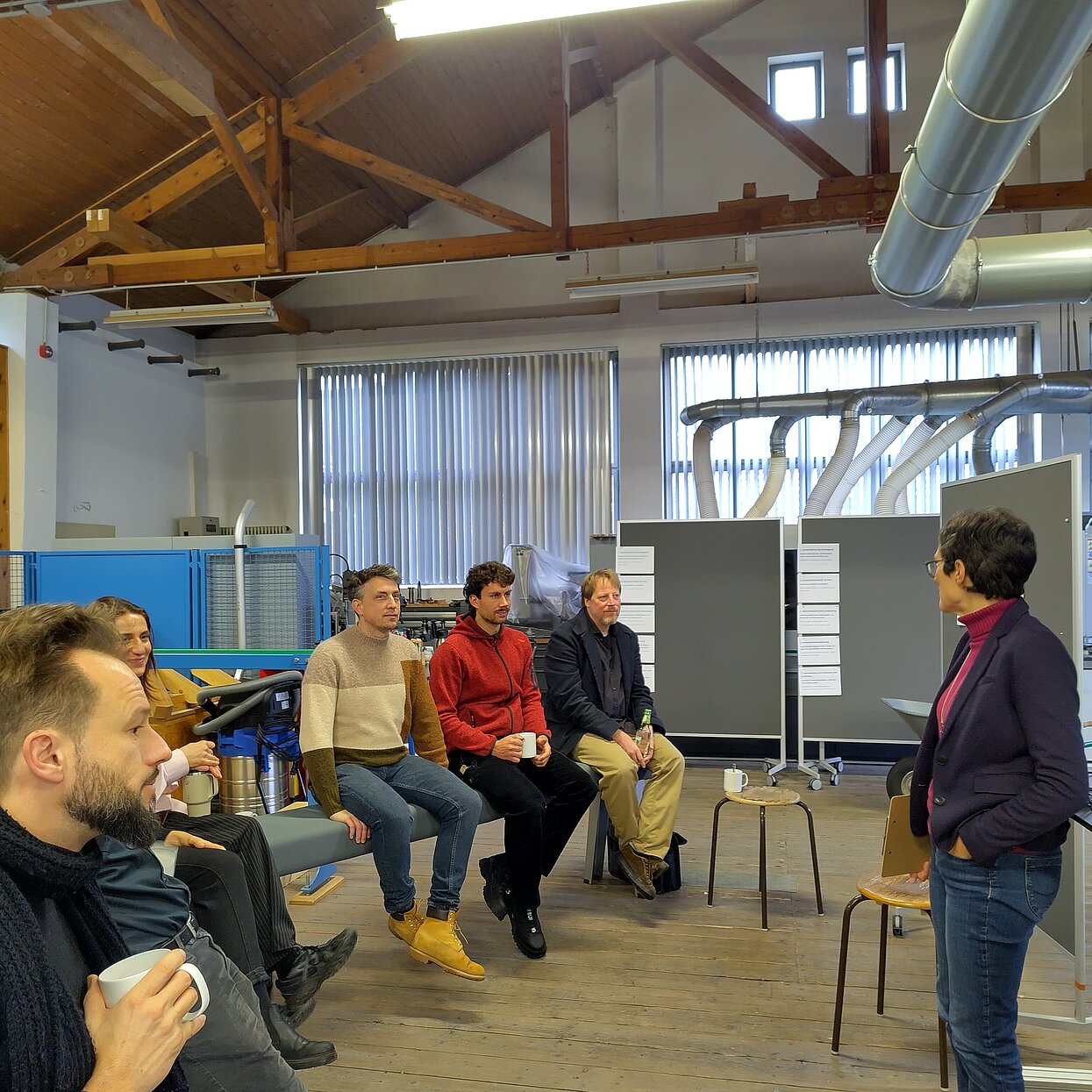 Referentin refreriert vor einer Gruppe in einem Labor-Sägewerk. 