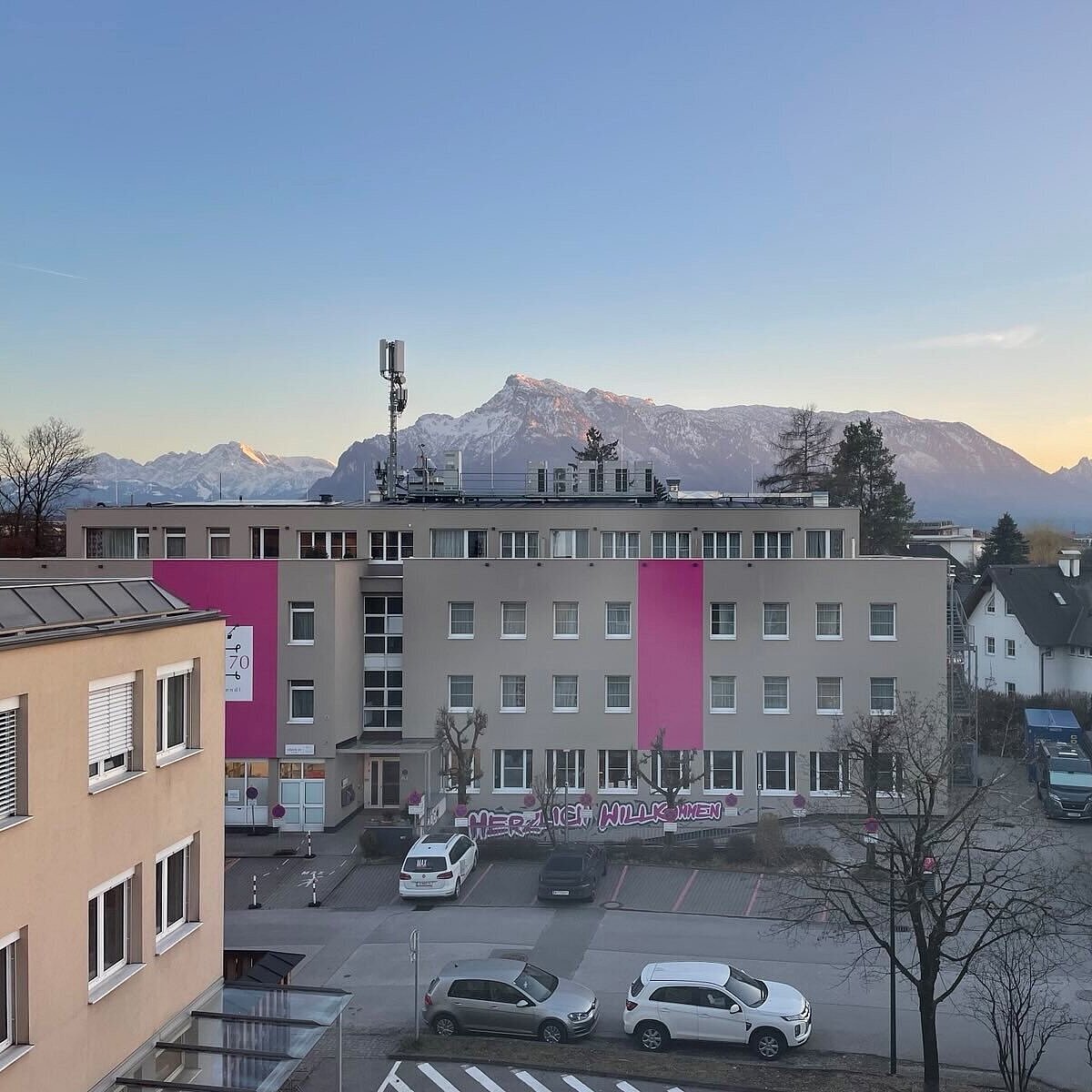 Häuser, offener Platz, parkende Autos, aus Vogelperspektive aufgenommen. 