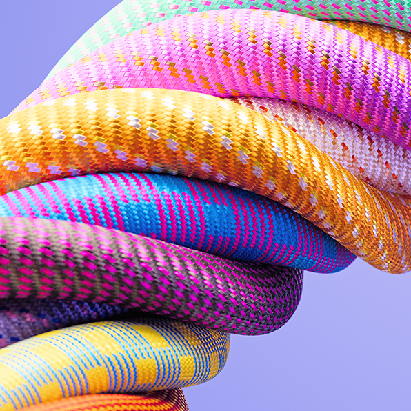 Mehrere in verschiedenen Farben unterschiedlich gemusterte Seile sind zu einem dicken Seil verwoben. Der Hintergrund ist hell.