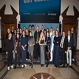 Tobias Gotthardt, Staatssekretär im Bayerischen Staatsministerium für Wirtschaft, Landesentwicklung und Energie, und Petra Lorenz, Geschäftsführerin des CommClubs Bayern e.V., stehen gemeinsam mit bayerischen Gewinnern und Gewinnerinnen des diesjährigen Cannes Lions auf einer Bühne.