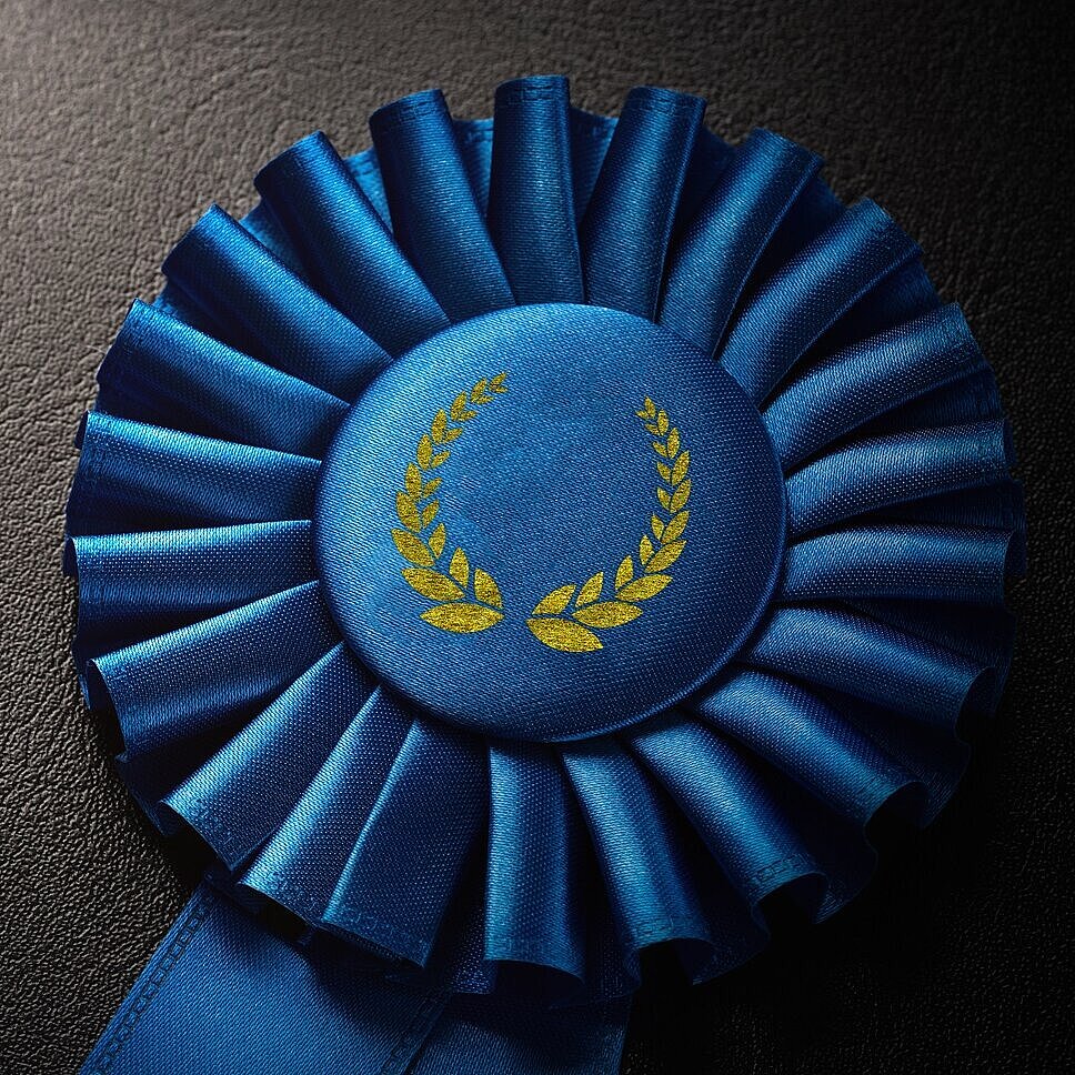Blaue Award-Rosette auf schwarzem Hintergrund