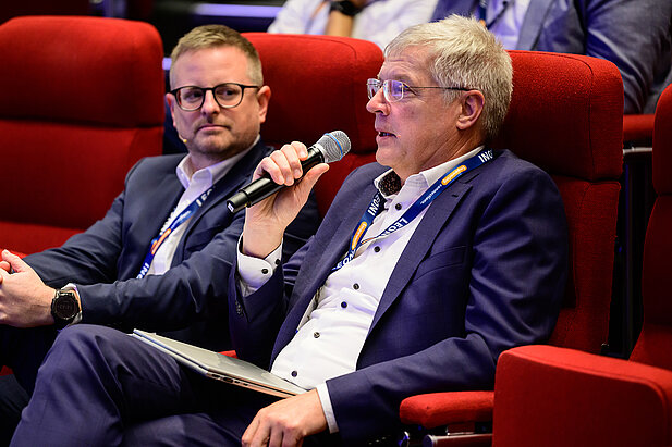 Frage aus dem Publikum beim Kooperationsforum Bordnetze 2025: Teilnehmer mit Mikrofon in der Hand