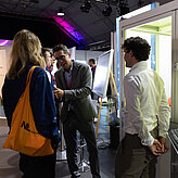 Das Bild zeigt drei Personen die sich unterhalten