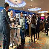 Picture of several people chatting and networking.