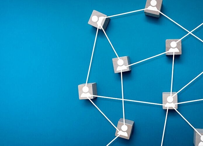 ChatGPT:  Das Bild zeigt ein Netzwerk aus kleinen Würfeln, die mit weißen Linien verbunden sind, auf blauem Hintergrund.