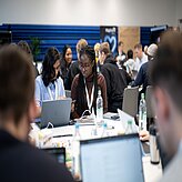 Menschen sitzen an Laptops und arbeiten