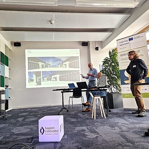 Zwei Personen halten einen Vortrag vor einer Präsentation. 