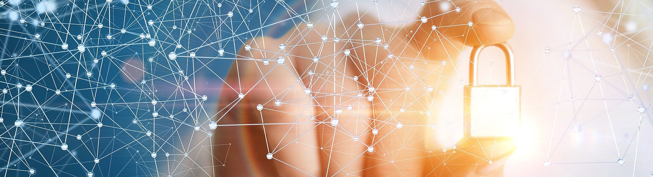 Eine Hand hält ein kleines goldenes Schloss zwischen Daumen und Zeigefinger in die Kamera