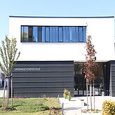 Bild von außen von der Landmaschinenschule Schönbrunn, weißes Gebäude mit dunkelgrauen Elementen