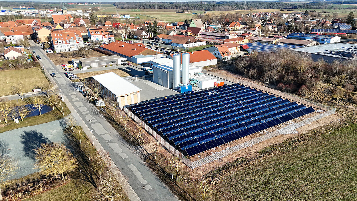 Ein Gebäude aus der Luft betrachtet, auf dem viele Photovoltaik Paneele montiert sind