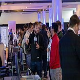 People explaining and listening on the Thinknet 6G Summit exhibition.