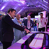 Das Bild zeigt vier Männer, sie schauen sich eine Ausstellung an