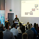 Ein Referierender spricht auf der Bühne 