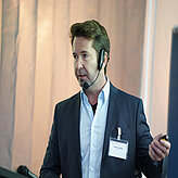 Ein Referierender spricht auf der Bühne